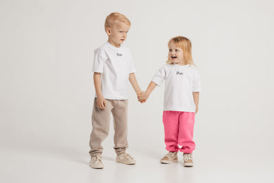 Berniukas ir mergaitė apsivilkę baltos spalvos vaikiškus marškinėlius